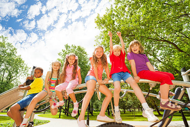 istock Kids sit on round bar of playground construction 507396447