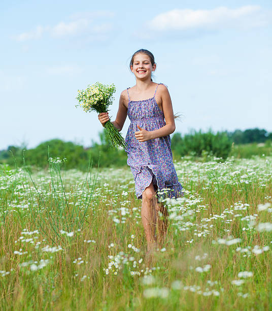 istock Girl with wild spring flowers 507396465