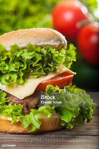 Cheeseburger Con Lechuga Y Tomate Cebolla En Un Nivel De Bun De Sésamo Foto de stock y más banco de imágenes de Alimento