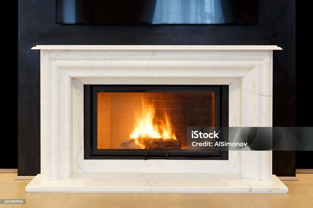 white, marble fireplace and burning fire. white, marble fireplace and burning fire Mantelpiece Stock Photo