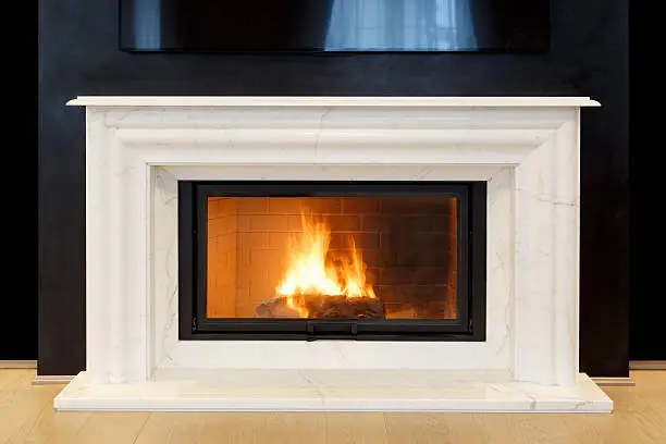 white, marble fireplace and burning fire