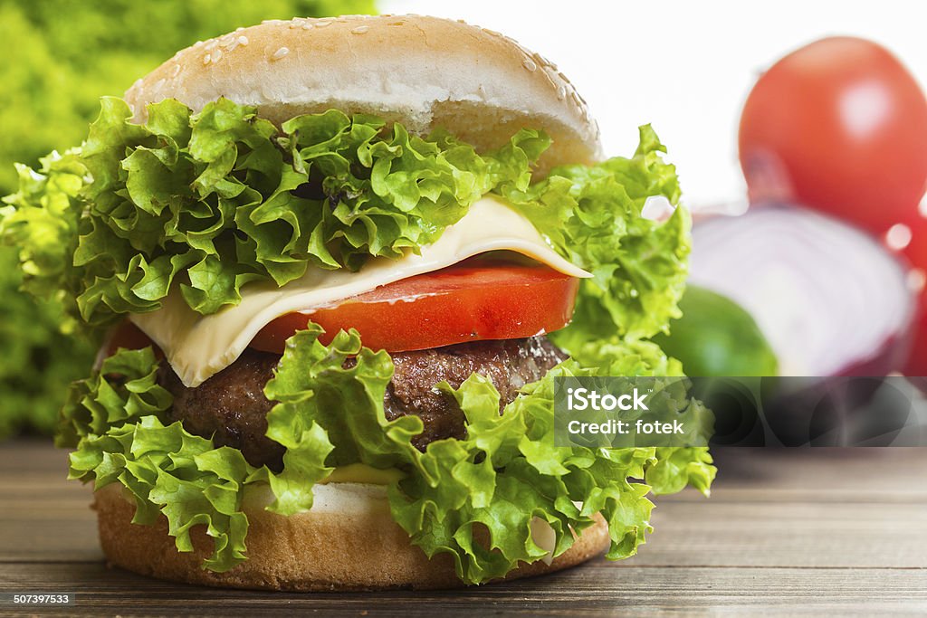 Cheeseburger con lechuga y tomate, cebolla en un nivel de bun de sésamo - Foto de stock de Alimento libre de derechos