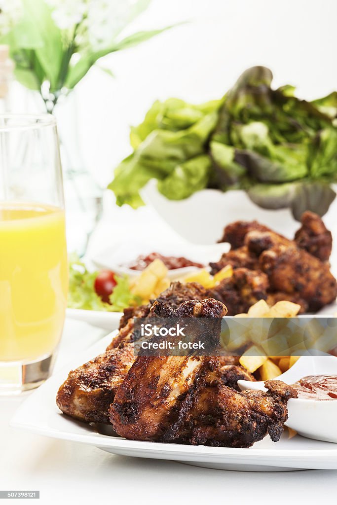 Alitas de pollo con salsa picante papas fritas y francesa - Foto de stock de Ala de animal libre de derechos