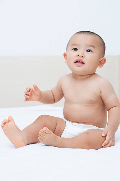 istock Cute Chinese baby boy sitting in bed 507398428
