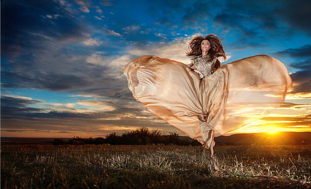 istock Woman spinning around looking as a butterfly in sunset 507398453