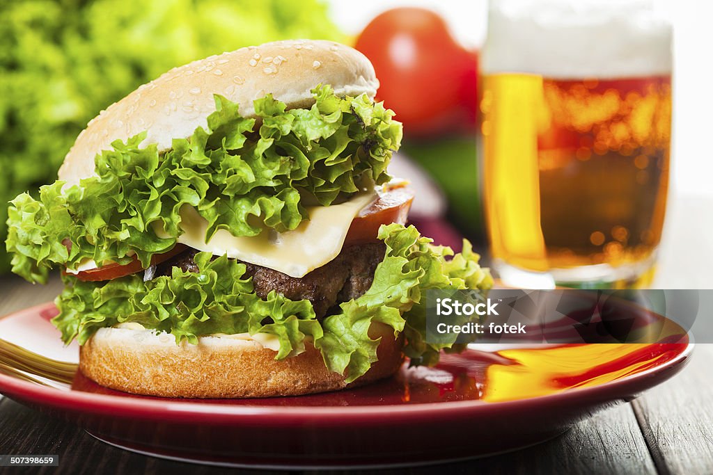 Hamburguesa con queso en una placa con cerveza - Foto de stock de Alimento libre de derechos