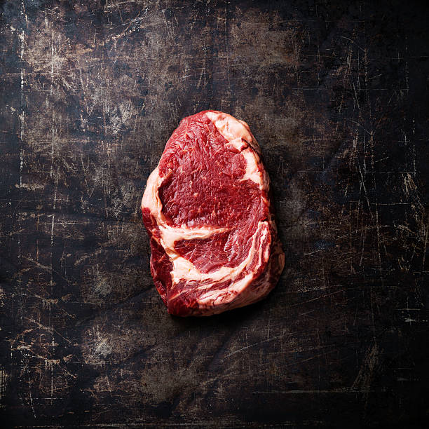 carne di manzo crudo su sfondo scuro - butcher meat butchers shop steak foto e immagini stock