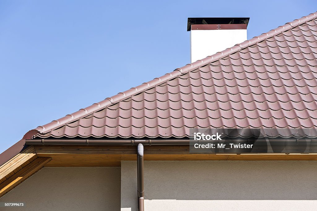 Rooftop with a rainwater drain Corner of a house with gutter and tiled roof Architectural Cornice Stock Photo