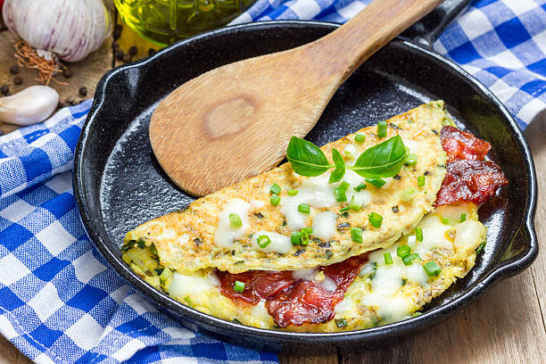 Bacon stuffed omelette on a iron cast pan stock photo