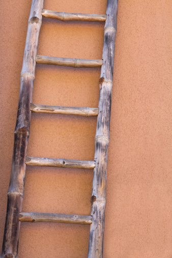A stepladder leaning against a wooden wall