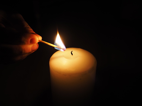 Group of Lit Church Candles, royal blue background.