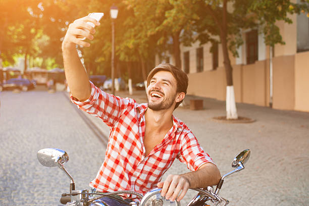 istock Young man sitting on scooter making selfie photo 507403870