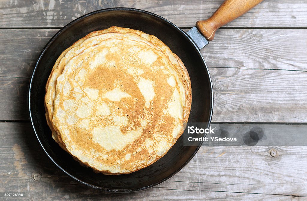 Stack of pancakes on a cast-iron frying pan. Stack of pancakes on a cast-iron frying pan. Top view Shrove Tuesday Stock Photo