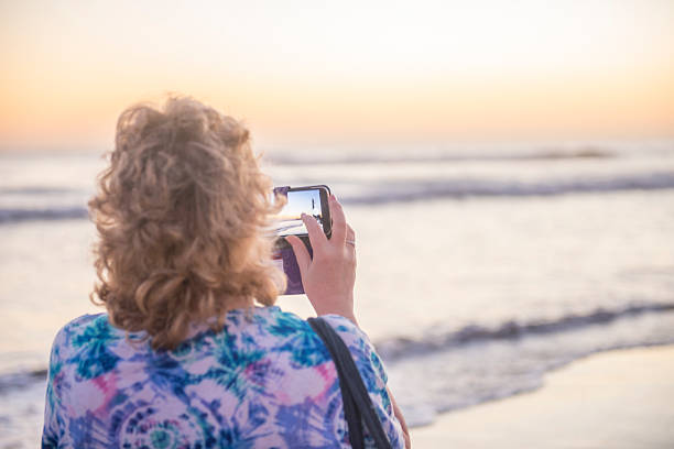 istock Lady photographing the sunset 507427278