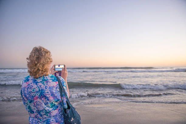 istock Lady photographing the sunset 507427604