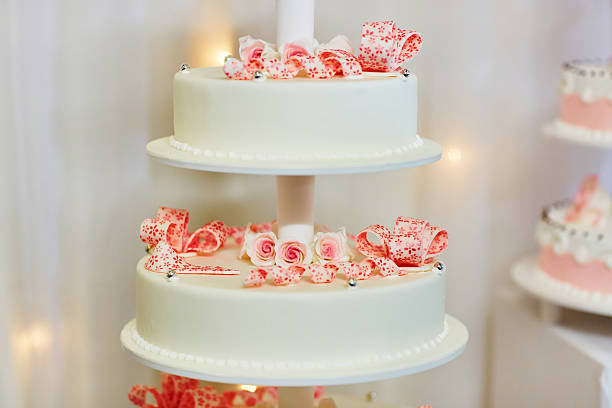 istock White wedding cake decorated with pink roses 507428404