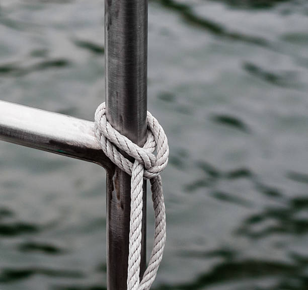 corde nouée à la balustrade près de l'eau en métal - chrome metal tied knot twisted photos et images de collection