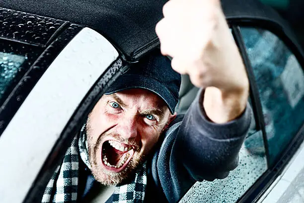 Photo of Road rage personified. Male driver yells, out of control