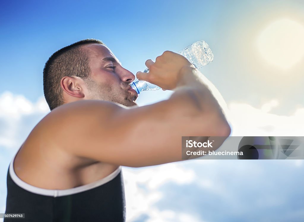 Hombre joven bebiendo agua - Foto de stock de 20 a 29 años libre de derechos