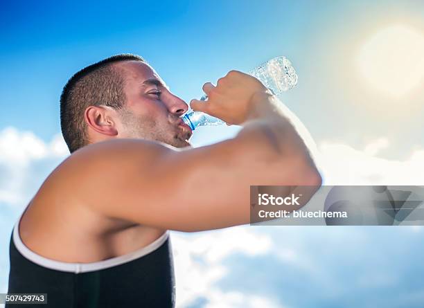 Hombre Joven Bebiendo Agua Foto de stock y más banco de imágenes de 20 a 29 años - 20 a 29 años, Actividades recreativas, Actividades y técnicas de relajación
