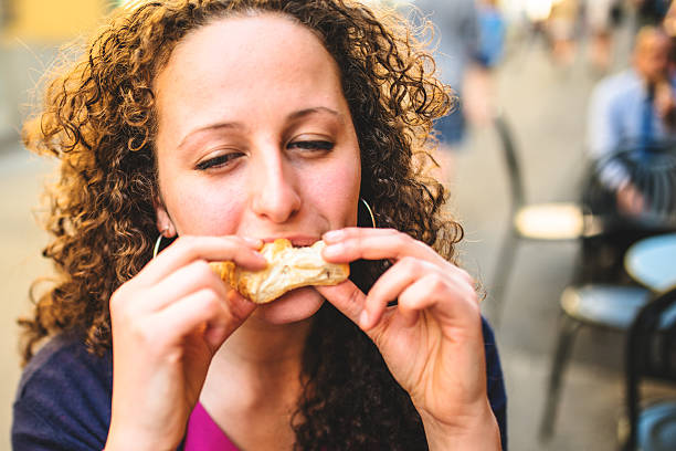 istock woman biting a snack at the cafe 507430495