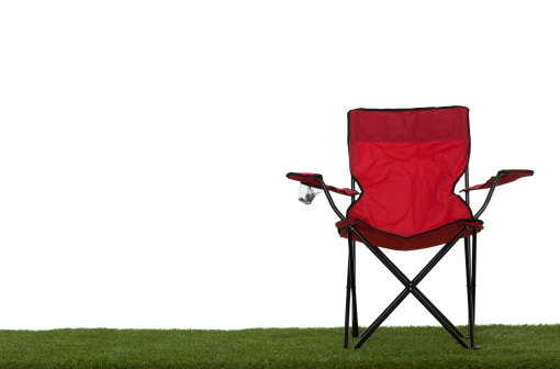 Folding camp chair front view on grass with white background