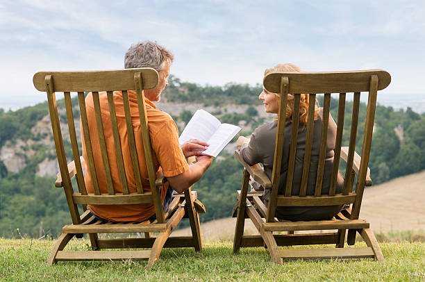 성숙한 커플입니다 독서모드 예약 - men reading outdoors book 뉴스 사진 이미지