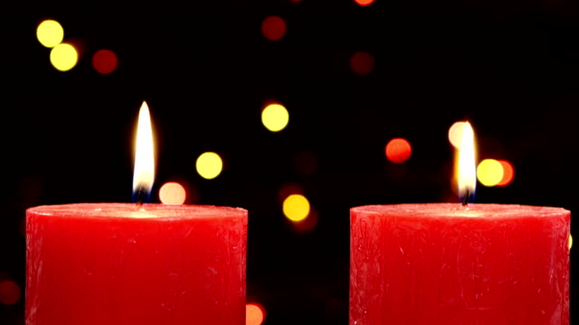Two red candles with christmas decorations on black, bokeh, light, garland, cam moves top down
