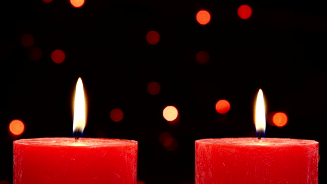 Two red candles with christmas decorations on black, bokeh, light, garland, dynamic change of focus