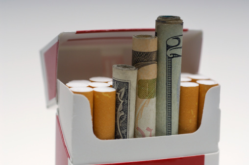Money rolled up in cigarette box, close-up