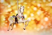 Antique carousel horse, golden festive lights background