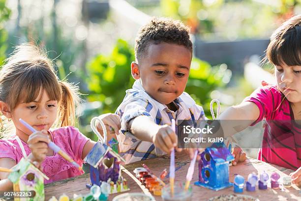 Multiethnic Children Painting Bird Houses Outdoors Stock Photo - Download Image Now