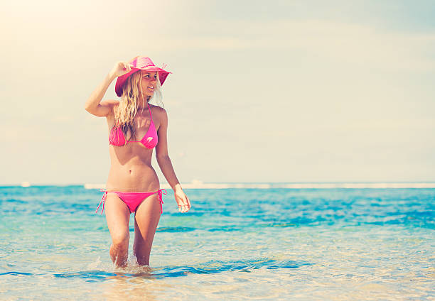 Rear-view of unrecognizable young Caucasian woman entering the sea