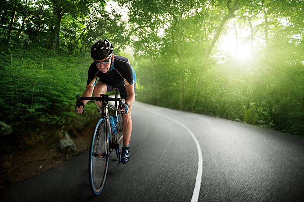 vélo cycliste vos pédales sur une forêt autoroute - cycling senior adult sports helmet men photos et images de collection