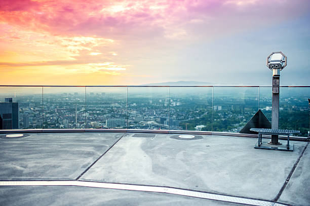 istock hand held Binoculars or telescope on top of skyscraper 507455447