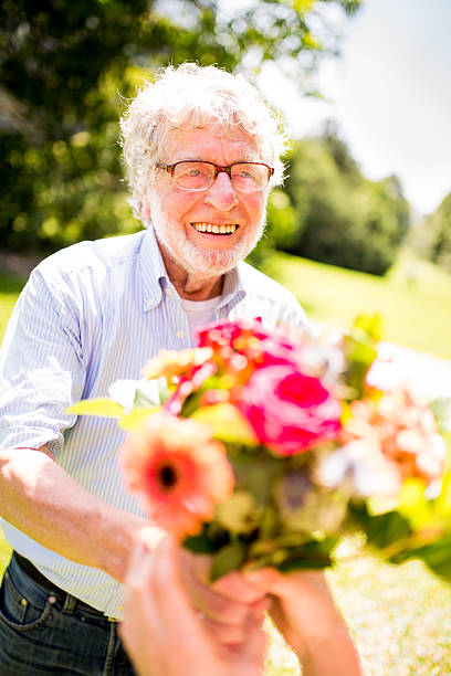 istock Happy Older Man Giving Flowers 507455563