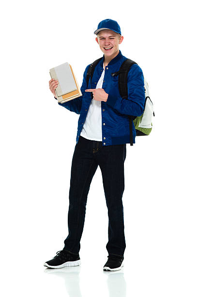 istock Cheerful student holding books and pointing 507456436