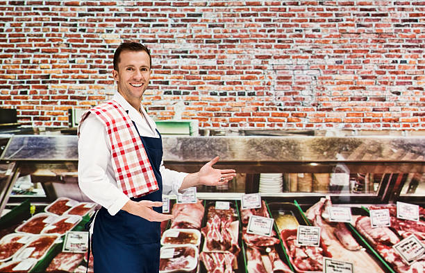 Smiling butcher presenting in store