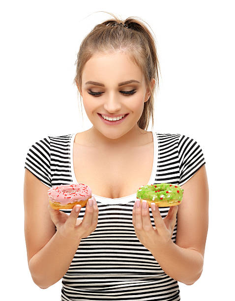 istock Funny girl taking colorful donuts. White background 507462186