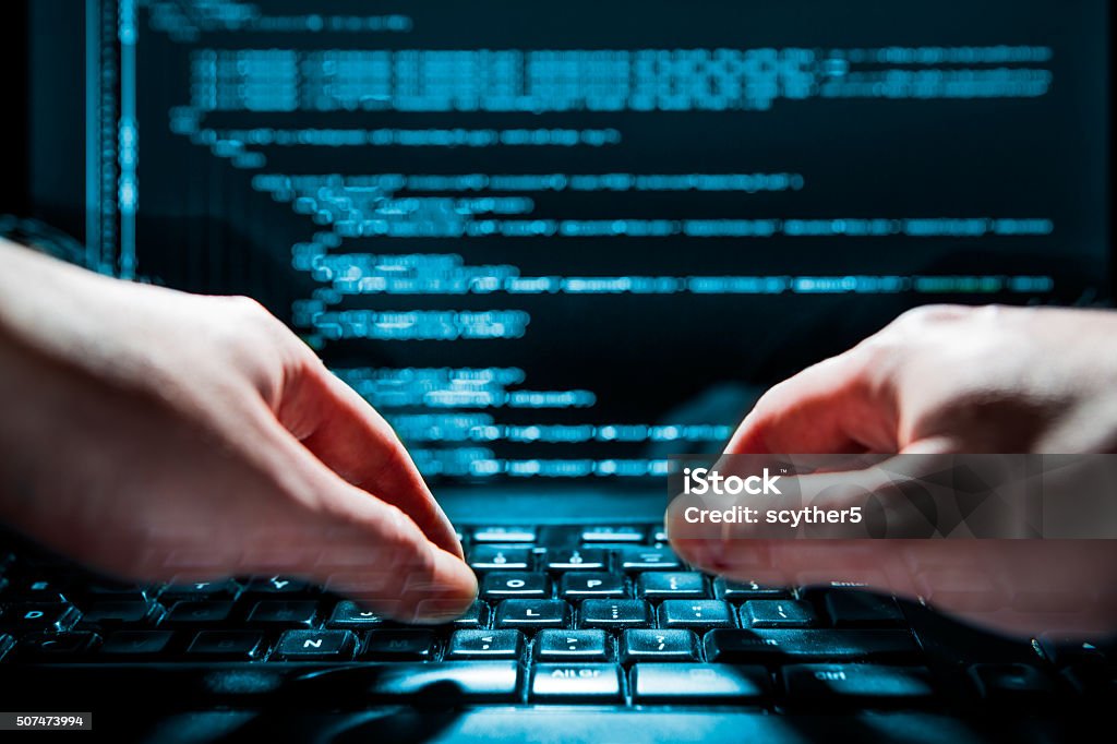 Computer crime concept Hacker using laptop. Lots of digits on the computer screen. Computer Hacker Stock Photo