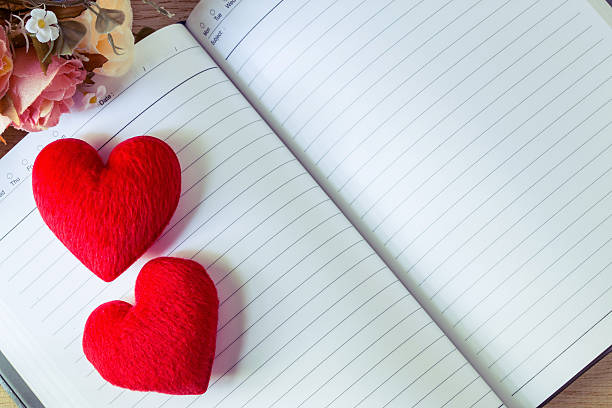 istock Blank notebook and hearts with flower on wooden table 507475916