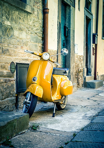 Yellow scooter in tuscan Cortona town stock photo