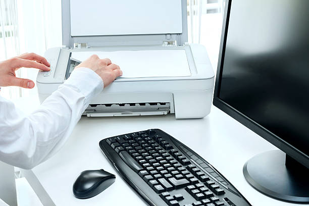 homem de negócios lê alguns documentos no local de trabalho com o'scanner' - print computer printer printout push button imagens e fotografias de stock
