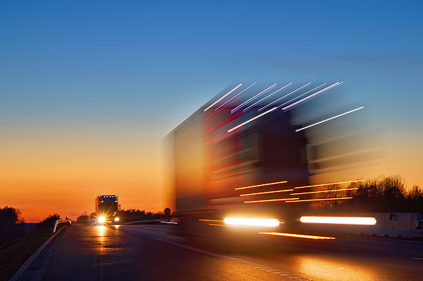 신속한 움직임감지 희미함 작업을 있는 트럭에 글로잉 조명 후 일몰 - truck horizontal shipping road 뉴스 사진 이미지