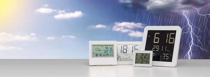 Weather station device with weather conditions outside background.
