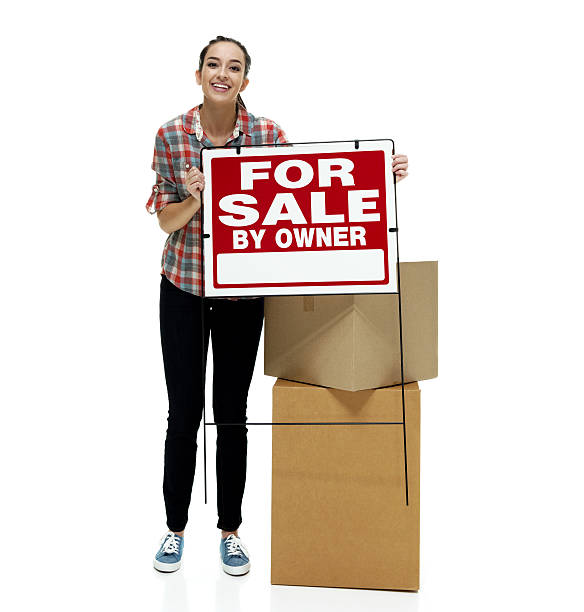 istock Smiling female showing for sale sign 507479664
