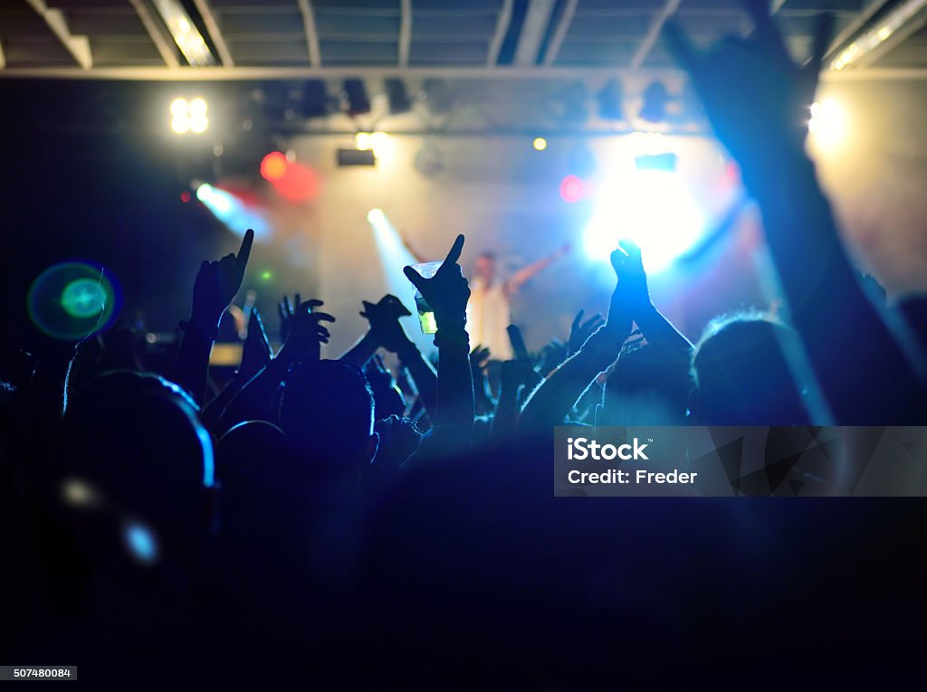 concert crowd silhouettes of people on a rock concert raising hands Performance Group Stock Photo