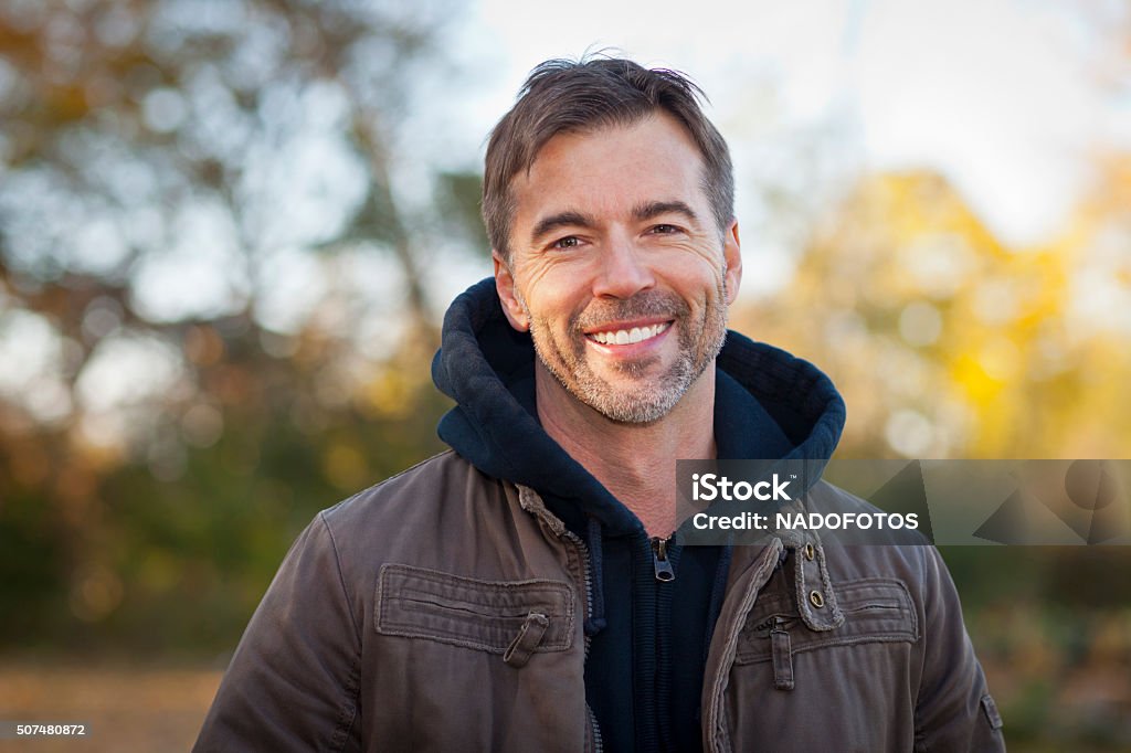 Portrait of A Mature Man Smiling at the camera Portrait of A Mature Man Smiling At The Park Men Stock Photo