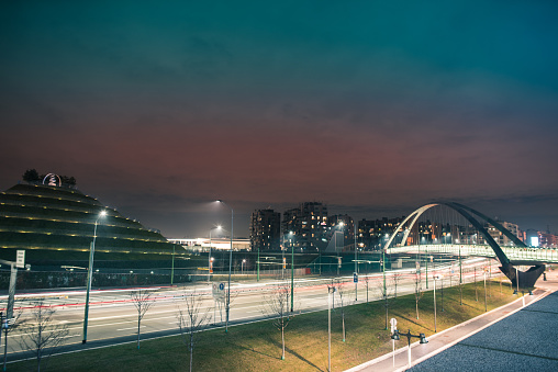 Fast traffic in a road and bridge in modern and futuristic city by night