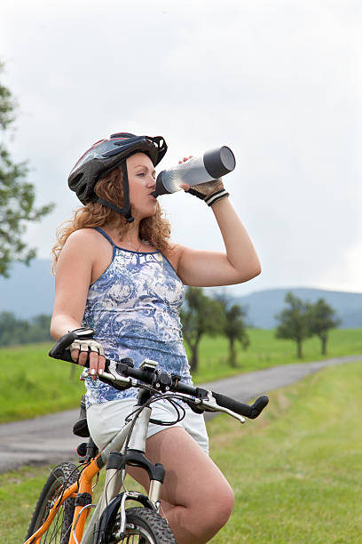 istock Mature woman mountain biker drinking water 507487037